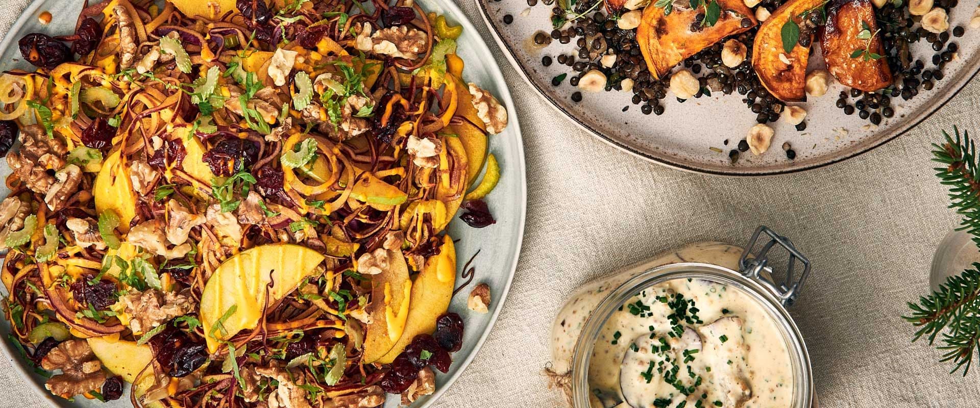 Två tallrikar med vegetarisk julmat och en burk med vegetarisk senapssill