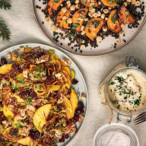 Två tallrikar med vegetarisk julmat och en burk med vegetarisk senapssill