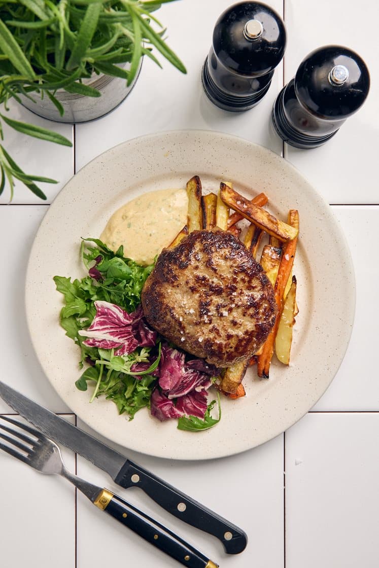 Steak haché med rotfruktspommes, Café de Paris-yoghurt och mixsallad