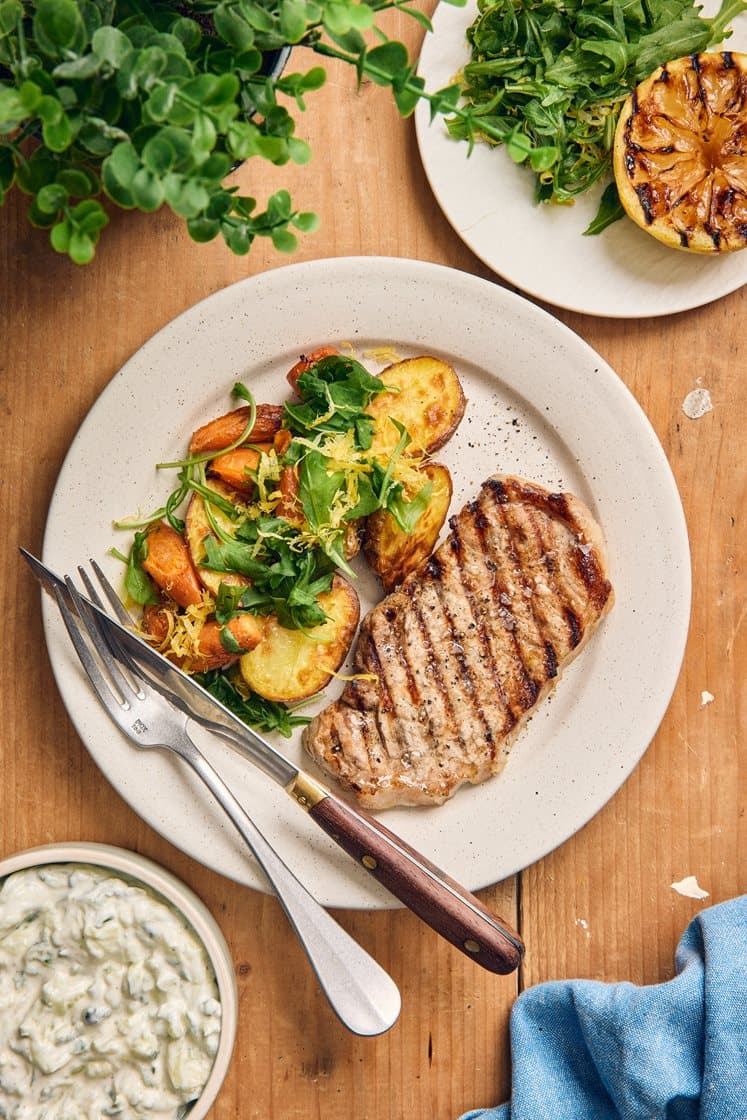 Grillad fläskkotlett med ruccola- och citronrostad potatis, tzatziki och grillad citron