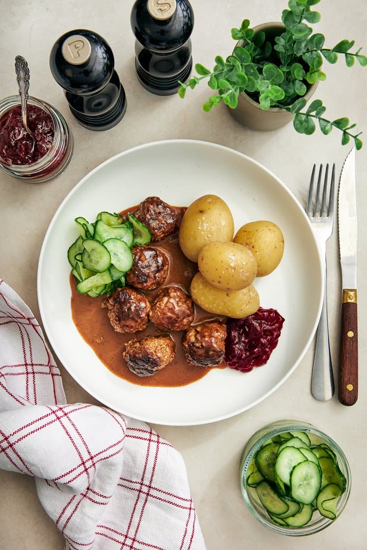 Klassiska köttbullar med gräddsås, pressgurka och rårörda lingon