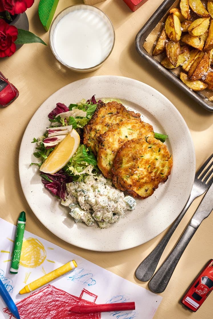 Zucchini- och cheddarplättar med klyftpotatis och krämig sallad