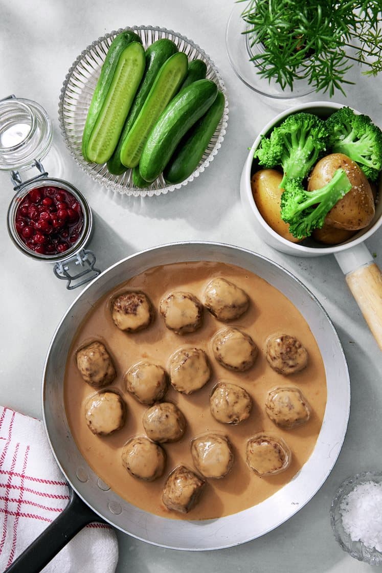 Köttbullar med gräddsås, gurka och rårörda lingon