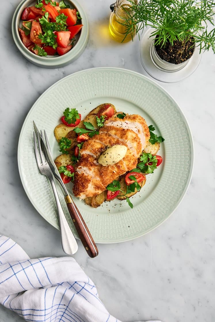 Pankostekt Bjärekyckling med pommes lyonnaise, salviasmör och tomatsallad