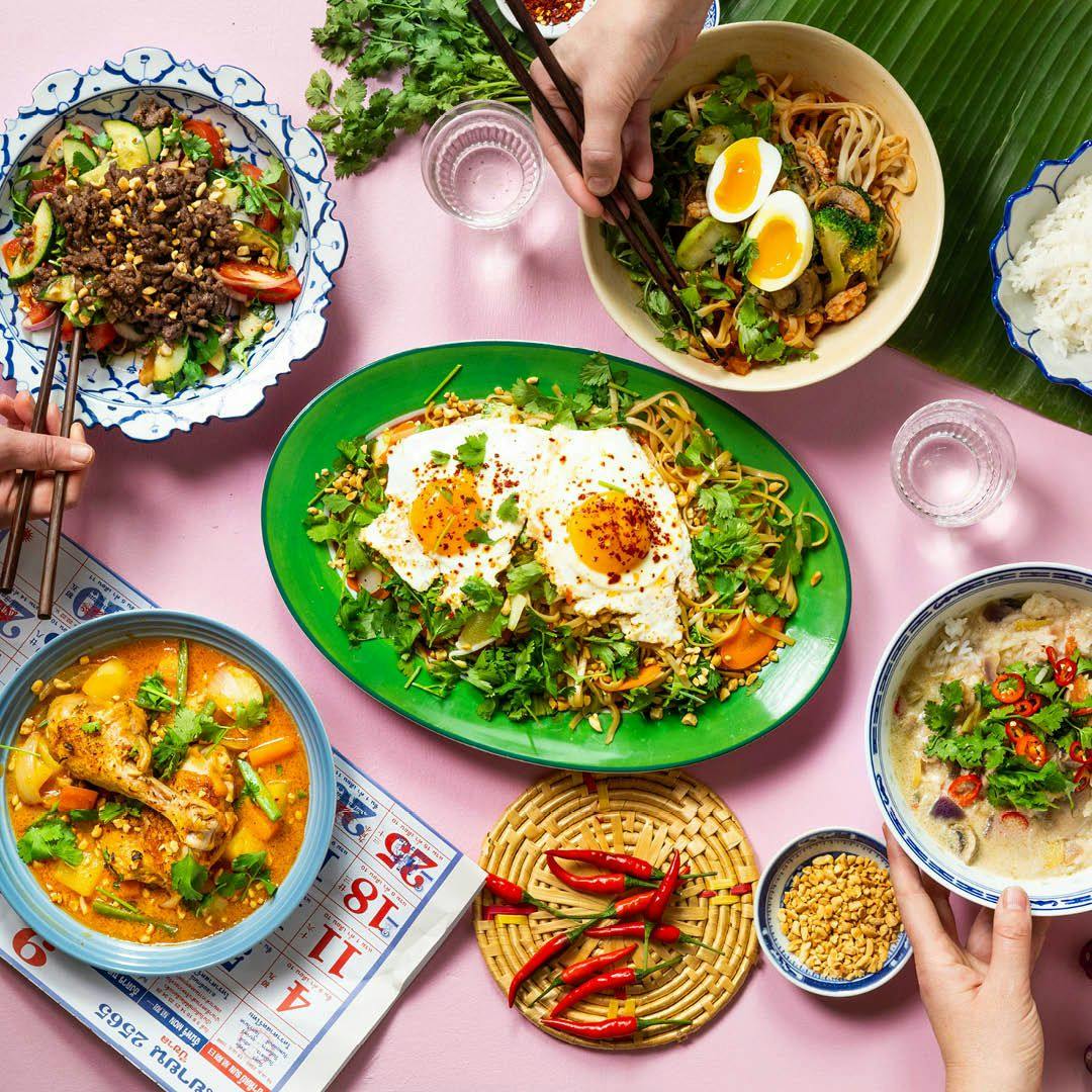 Fem färgglada tallrikar med thailändsk mat