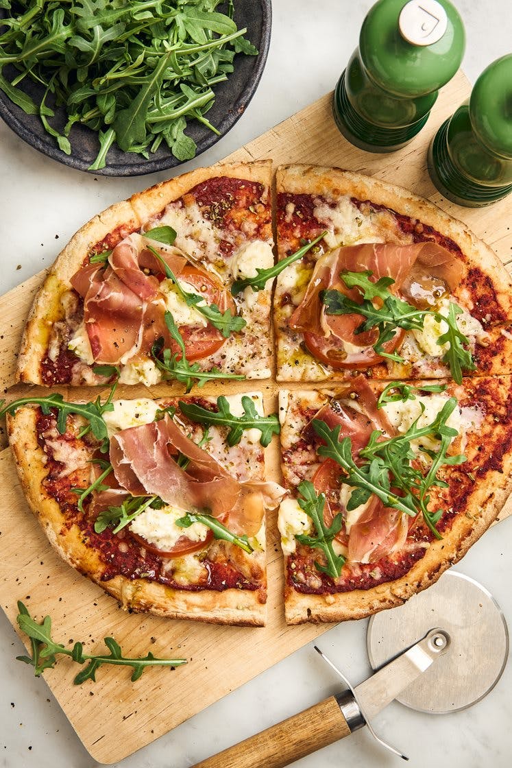 Pizza caprese med prosciutto, ruccola och basilikaolja